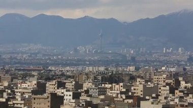Binaların üzerinde güneş ışığı ile İran İslam Cumhuriyeti'nin başkenti Tahran şehir manzarası uzun çekim