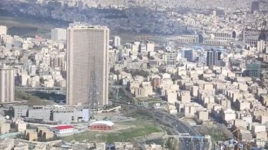 Binaların üzerinde güneş ışığı ile İran İslam Cumhuriyeti'nin başkenti Tahran şehir manzarası uzun çekim