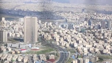 Binaların üzerinde güneş ışığı ile İran İslam Cumhuriyeti'nin başkenti Tahran şehir manzarası uzun çekim