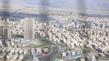 Binaların üzerinde güneş ışığı ile İran İslam Cumhuriyeti'nin başkenti Tahran şehir manzarası uzun çekim