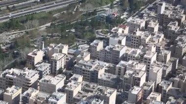 Binaların üzerinde güneş ışığı ile İran İslam Cumhuriyeti'nin başkenti Tahran şehir manzarası uzun çekim