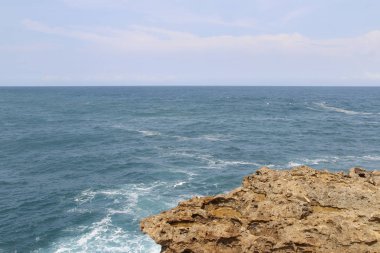 Güneşli bir gün, Yogyakarta, Endonezya Timang Plajı'nda dalga ile doğal kaya oluşumu