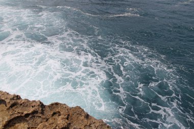 Güneşli bir gün, Yogyakarta, Endonezya Timang Plajı'nda dalga ile doğal kaya oluşumu