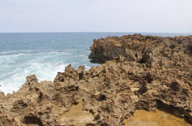 Güneşli bir gün, Yogyakarta, Endonezya Timang Plajı'nda dalga ile doğal kaya oluşumu
