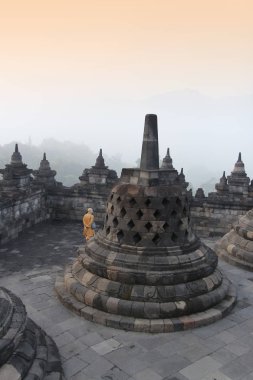 Yogyakarta, Endonezya - 22 Nisan 2018: Gizemler orman şafakta çevreleyen ile Borobudur Tapınağı dolaşan bir keşiş