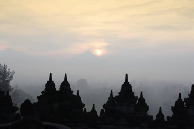 Gizemler orman günbatımı sırasında Yogyakarta, Endonezya çevreleyen ile siluet Borobudur Tapınağı
