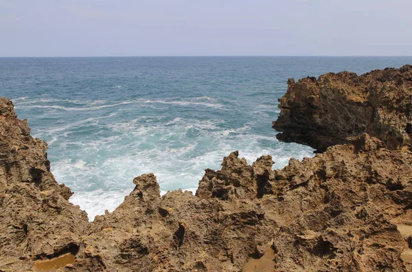 Güneşli bir gün, Yogyakarta, Endonezya Timang Plajı'nda dalga ile doğal kaya oluşumu