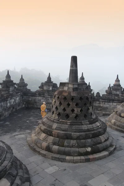 Yogyakarta, Endonezya - 22 Nisan 2018: Gizemler orman şafakta çevreleyen ile Borobudur Tapınağı dolaşan bir keşiş