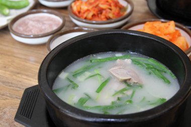 Korean pork rice soup (Dwaeji-gukbap) in a steaming stone bowl with the side dishes at Korean restaurant, Busan, South Korea