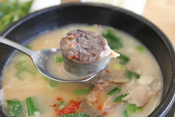 Korean pork rice soup (Dwaeji-gukbap) with the focus on rice with pork intestine in a steaming stone bowl at Korean restaurant, Busan, South Korea