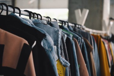 Women clothing on hangers in a boutique store clipart