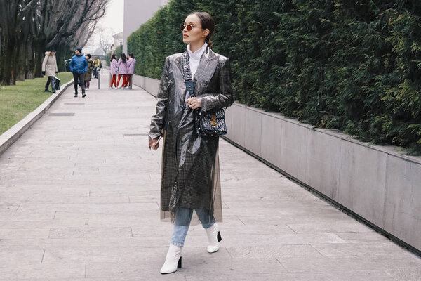Milan, Italy - February 24, 2018: Fashion appearance of a fashionista with stylish clothing and accessories during Milan Fashion Week.