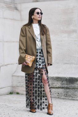 Paris, France - February 28, 2019: Street style outfit -  Woman wearing sheer skirt, brown blazer, knit before a fashion show during Paris Fashion Week - PFWFW19 clipart