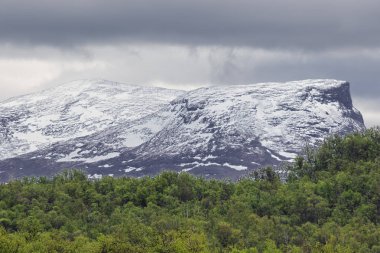 Dağlar Abisko Milli Parkı'nda sisli bulutları ile örtülü kar maskeli
