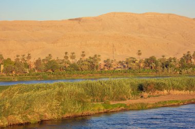 Ezbet El-Gawad aydınlatan Nil kıyısında Altın güneş ışınları