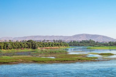 Arka planda dağları olan Armant Adası, Luxor yakınlarında