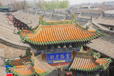 Pingyao'da şehir duvarından görülen bir şehir kapısının renkli kiremitli çatısı