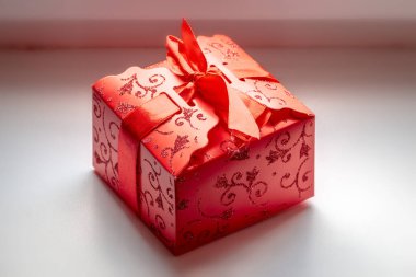 Kırmızı kurdeleli kırmızı pakette bir hediye..