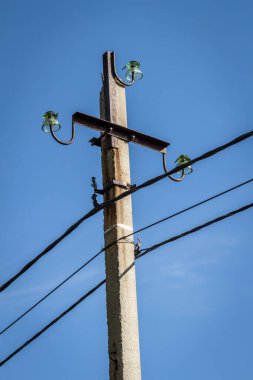 Mavi gökyüzüne karşı yüksek elektrik direği.