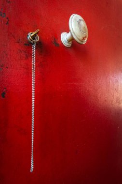 Demir kırmızı bir kapı ve zincirli bir anahtar..