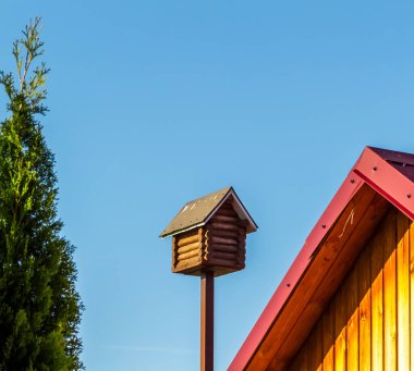 Mavi gökyüzüne yakın ahşap bir kuş evi..