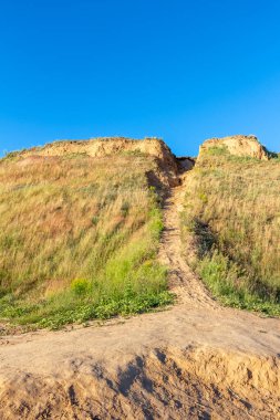 Dağın zirvesine giden dik toprak yol..