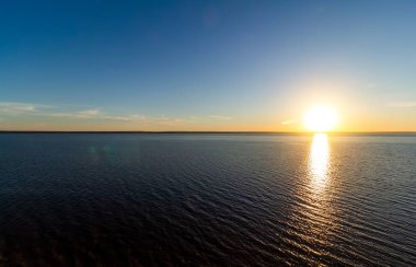 Büyük bir denizin yüzeyinde güzel bir günbatımı.