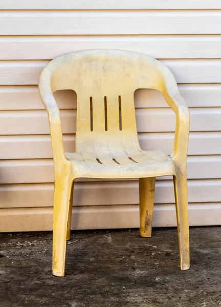 Stary Żółty Plastikowy Fotel Stoi Przy Ścianie Podwórku — Zdjęcie stockowe