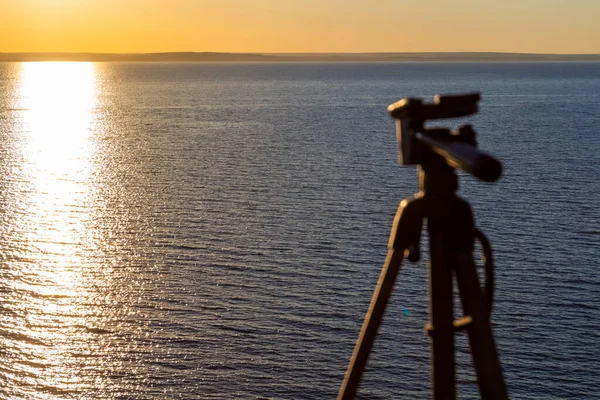 The tripod is ready to work and is mounted on top of a mountain with sea views.