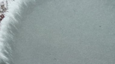 El fırçasıyla kardan arabanın camını temizliyorum..