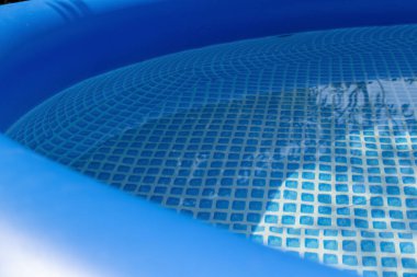 Özel bir evin arka bahçesindeki mavi şişme havuzun bir parçası..