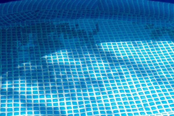 Part of a blue inflatable pool in the backyard of a private house.