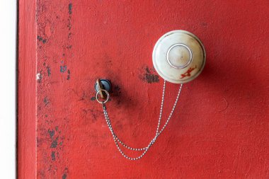 Eski bir kırmızı metal ön kapının kilidi ve sapı.