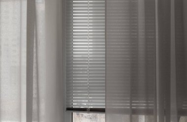 Yatay beyaz panjurlar güneş ışığını engeller.