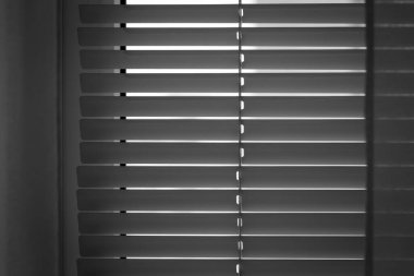 Yatay beyaz panjurlar güneş ışığını engeller.