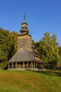 Ormanın yakınındaki tepede eski ahşap bir kilise. Sonbahar kırsal bölgeleri