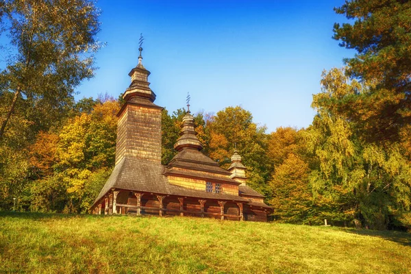 Старая деревянная церковь на холме возле леса. Осенний сельский ландшафт — стоковое фото