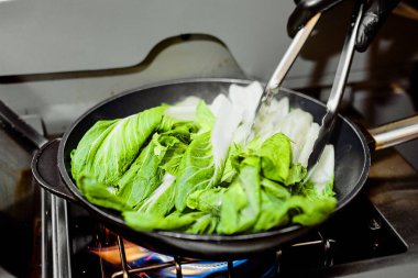 yanan bir soba üzerinde bir tavada marul yaprakları