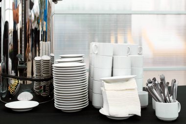 Beyaz kupalar, tabak ve kaşık üzerinde bir büfe tablo kümesi