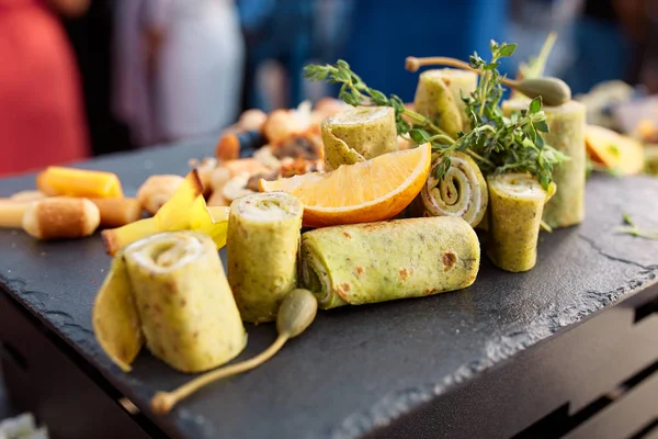 Green pancake rolls with orange in a restaurant — Stock Photo, Image