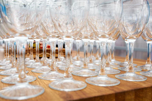 A lot of empty wine glasses on a wooden table — Stock Photo, Image