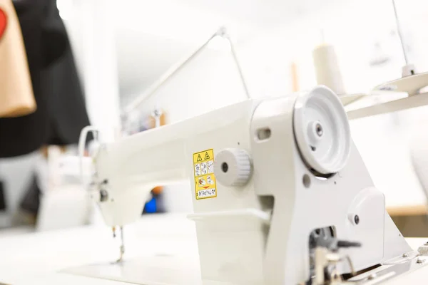 Máquina de coser blanca en la mesa en el taller —  Fotos de Stock