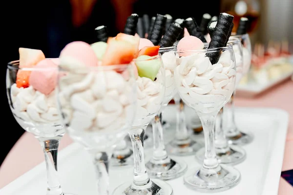 Vasos de vidrio con bocadillos de frutas y crema en la mesa —  Fotos de Stock