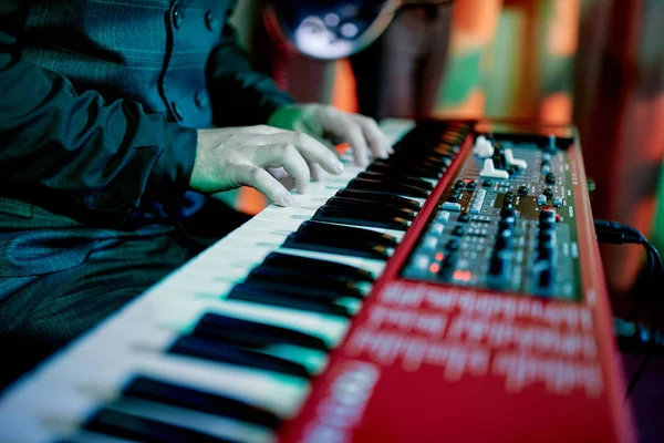 Musician plays a red synthesizer — Stock Photo, Image