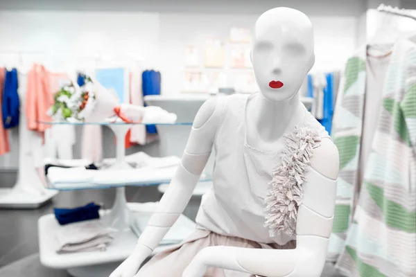 Белый манекен с красными губами в магазине одежды — стоковое фото