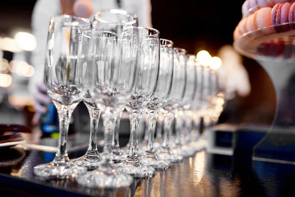 Empty champagne glasses on a table with macaroons — Stock Photo, Image