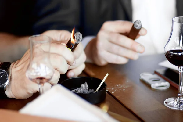 erkekler elleriyle bir puro ve mulled şarap bardak