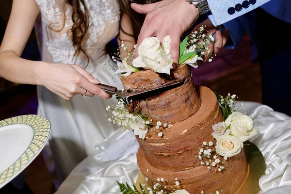 the newlyweds cut off the first piece of the wedding cake