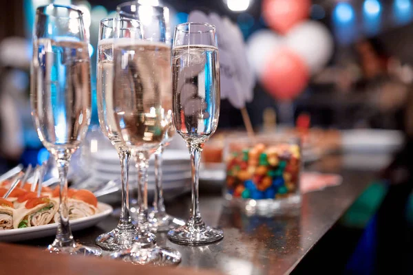Bir masada aperatifler ile şampanya dört bardak — Stok fotoğraf