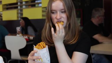 Kerpen, Almanya - 9 Ağustos 2025: McDonalds restoranında waffle yiyen kadın.